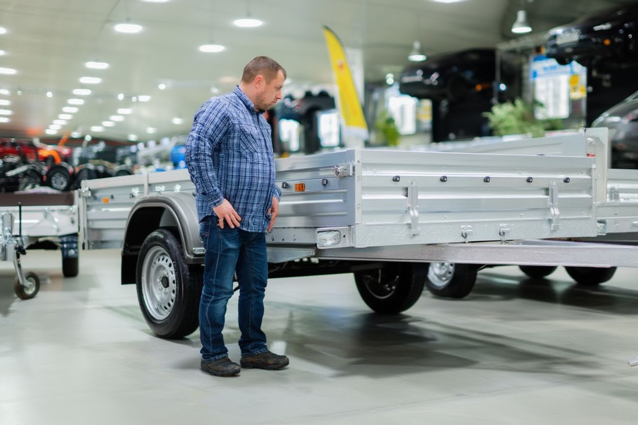 Процесс выбора усиленного бортового прицепа в выставочном зале